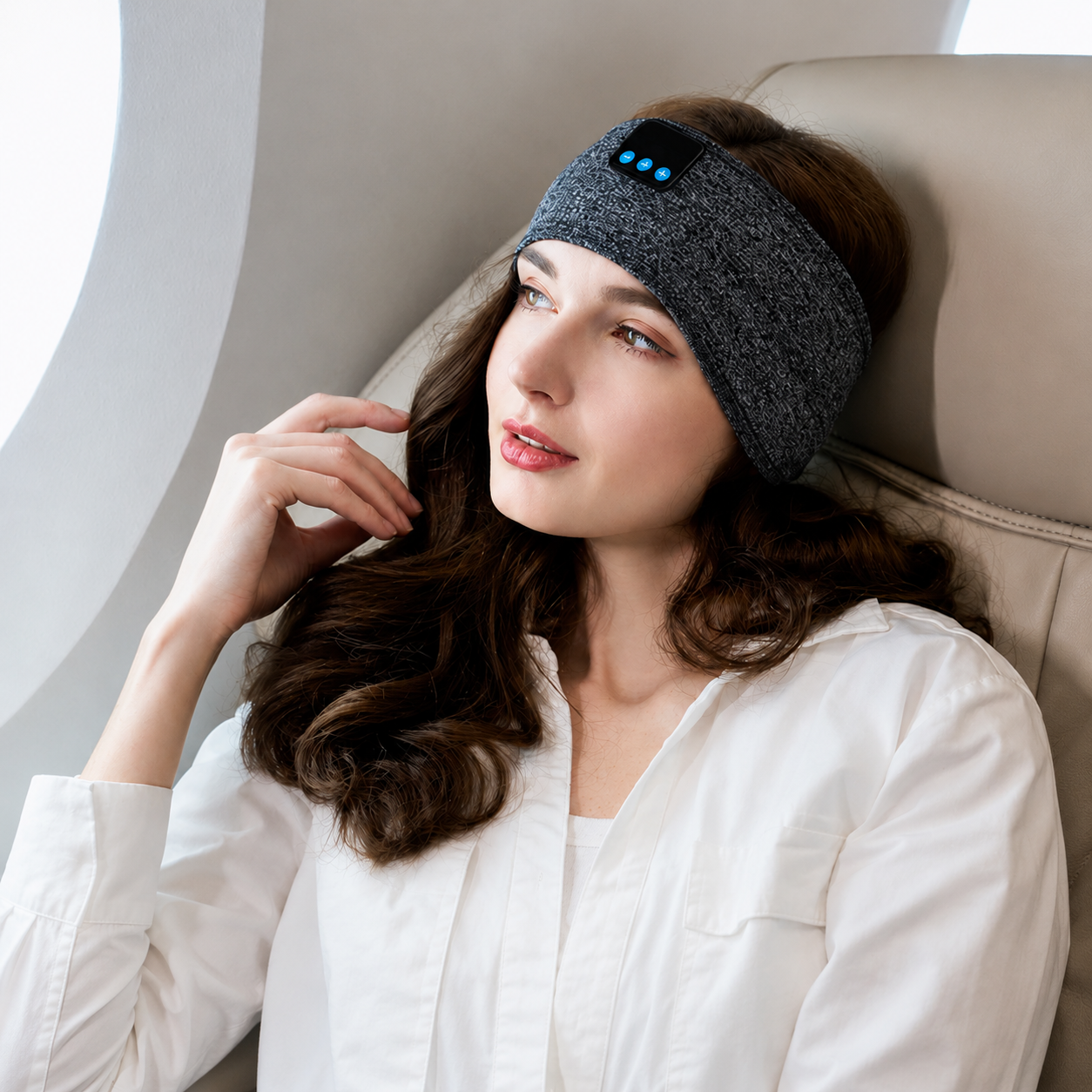 femme assis dans une avion avec le Bandeau Bluetooth autour de la tête